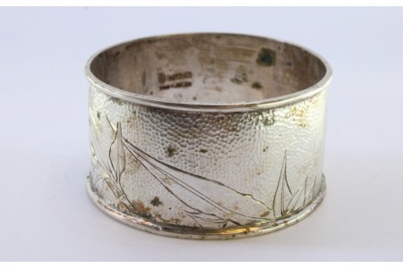 Argola de guardanapo em prata martelada com rebordo e motivos florais.